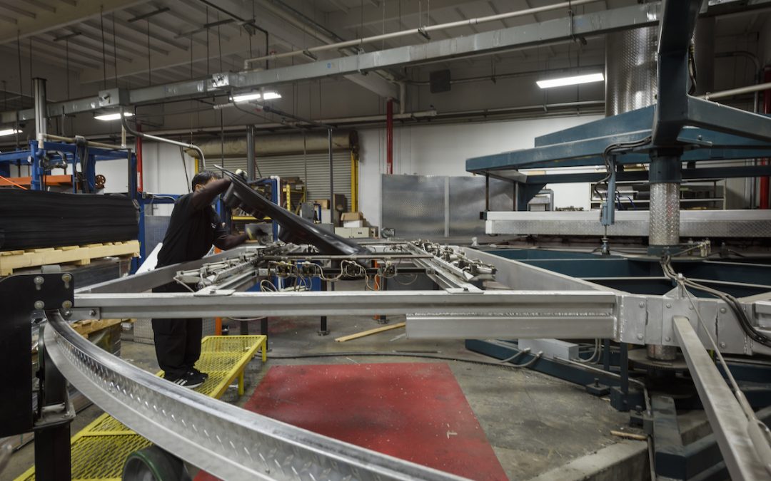 A person operates machinery in an industrial setting, surrounded by various equipment and metal structures, seamlessly integrating vacuum forming technology into the process.